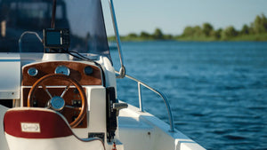 Boat deck with steering wheel on open water, illustrating common mistakes to avoid when installing boat carpet for a professional finish.